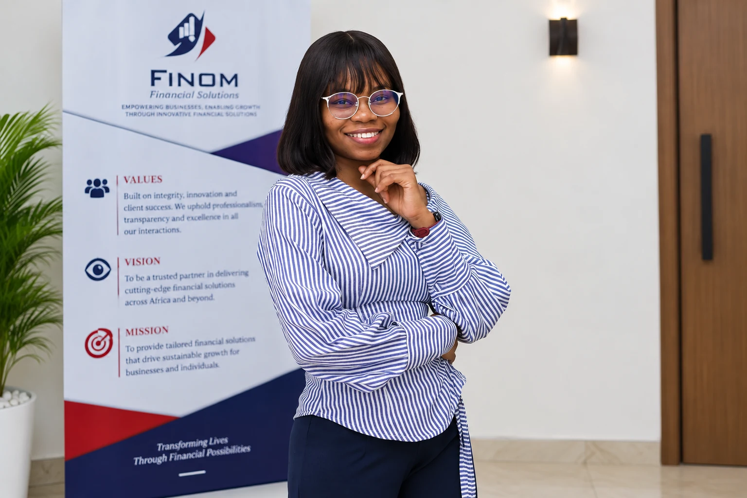 A FINOM professional standing beside the organisation's values, vision, and mission display